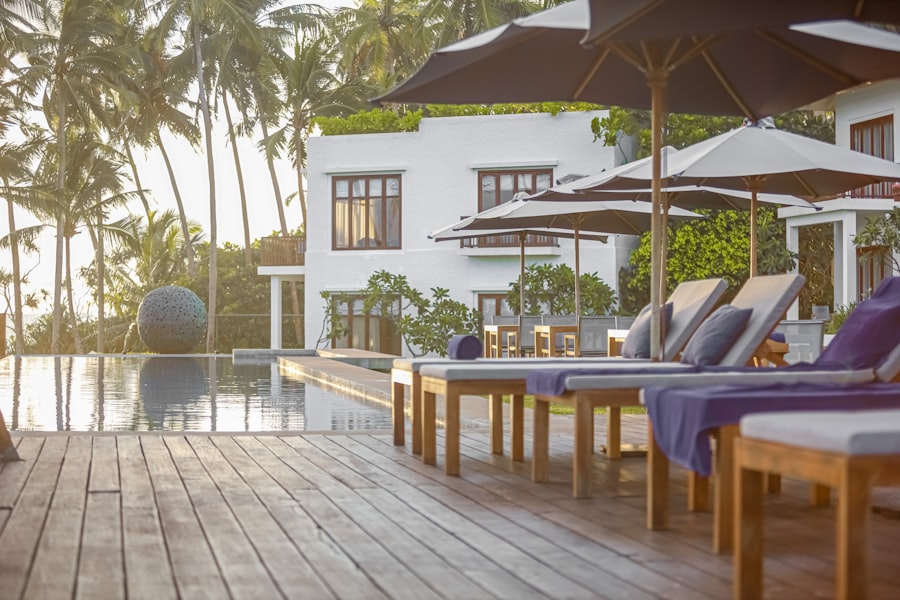 Wooden deck with chairs and umbrellas beside a pool